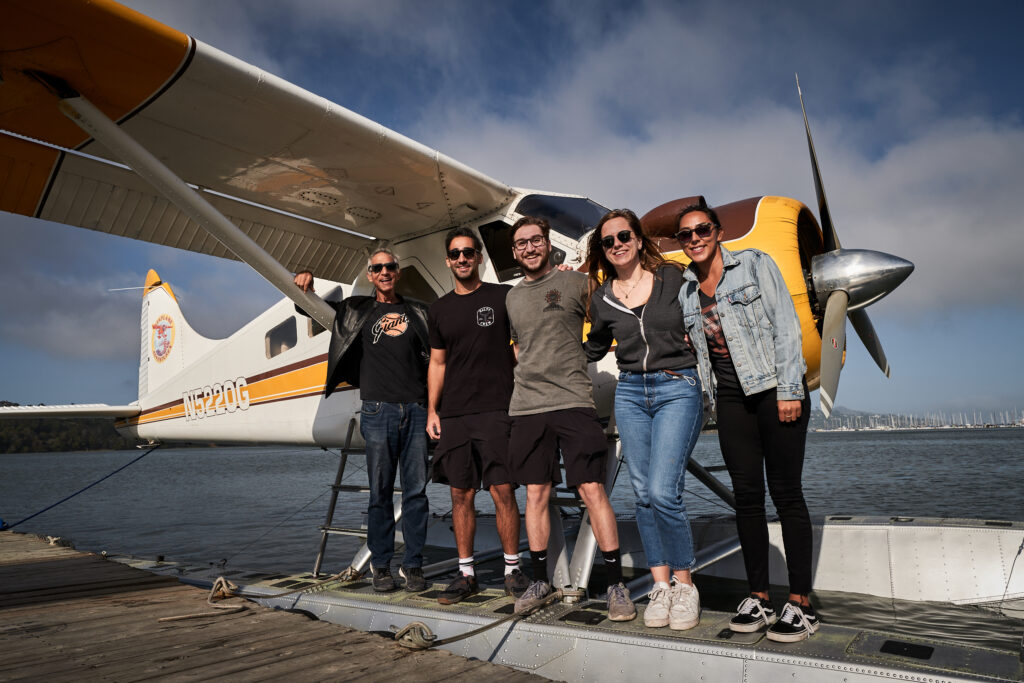 group standing by seaplane on dock
