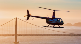 helicopter over golden gate bridge at sunset