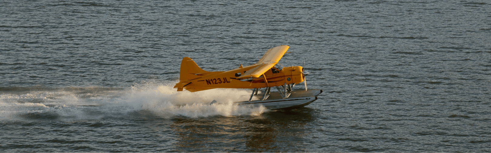 a yellow seaplane landing in the sf bay