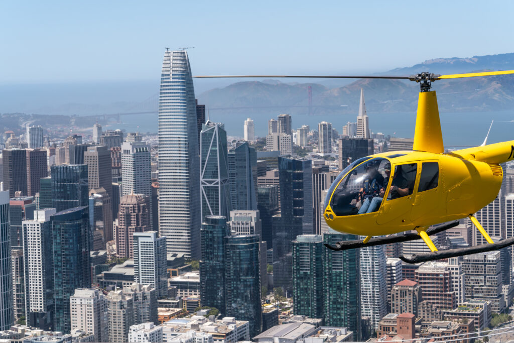 A yellow helicopter flying over San Francisco